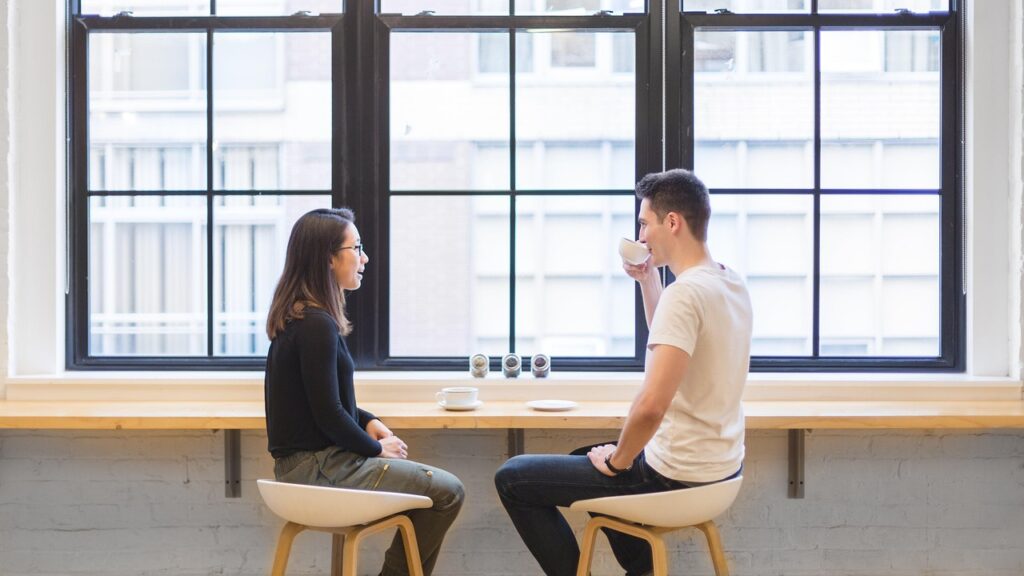 カフェで向かい合って会話する男女